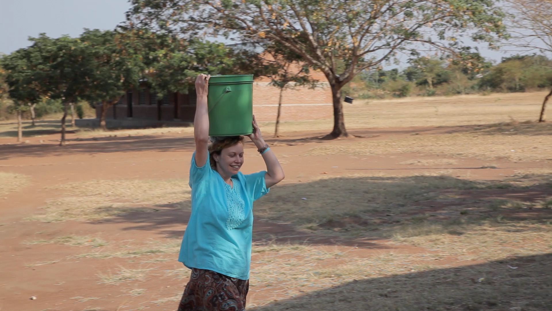 Susan carrying water on her head 
