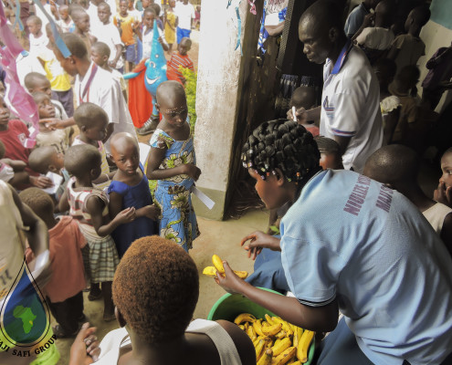 Community Health Worker Lilian Kayuni handing out bananas to the children after they washed their hands.